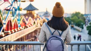 遊園地を見つめる帽子の人物の後ろ姿
