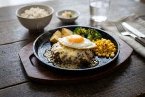 鉄板で焼ける目玉焼きとチーズ乗せのハンバーグ