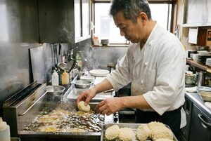 油に揚げ入れるコロッケと料理人