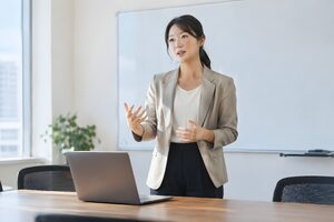誰もいない会議室でプレゼンのリハーサルをする30代女性