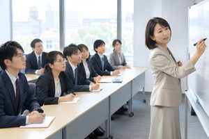 ホワイトボードに書きながら社内研修を進める40代女性講師