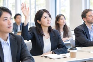 セミナー中に手を挙げて質問する30代女性