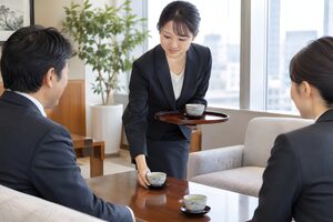 応接室で来客にお茶を出す20代女性