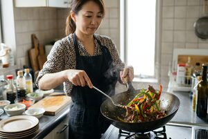 青椒肉絲を炒める女性