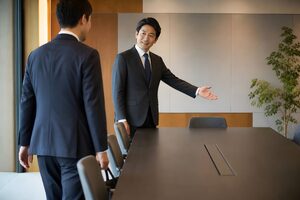 来客を上座へ案内する40代男性