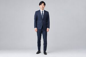 正しい姿勢で立つスーツ姿の30代男性の全身