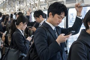 朝の満員電車でつり革を持つスーツ姿の会社員たち