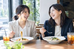 オフィス近くのカフェでランチをとる30代女性2人