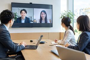会議室のスクリーンにリモート参加者を映したハイブリッド会議