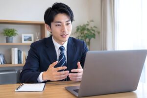 自宅のノートパソコンでオンライン面接を受ける20代男性