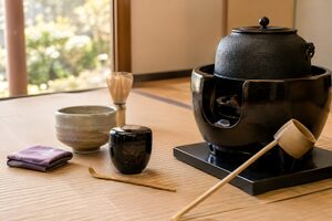畳に並んだ茶釜、柄杓、棗、茶杓などの茶道具