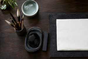 筆と硯、墨、文鎮を並べた書道道具の俯瞰