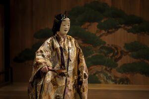 松の鏡板を背に能面をつけて立つ能の演者
