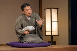 高座で扇子を手に語る50代の落語家