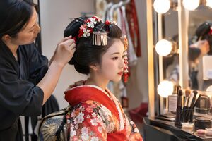 本番前に楽屋でかんざしを整えてもらう踊り手