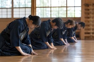 稽古の始めに正座で礼をする剣道の部員たち