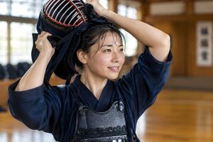稽古の後に面を外す20代の女性剣道家