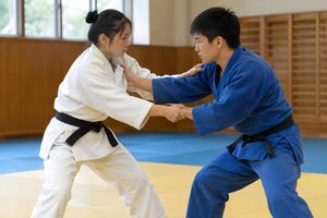 畳の上で組み合う白と青の柔道着の選手