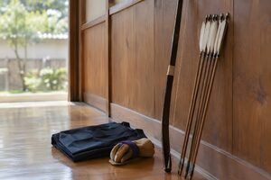 道場の壁に立てかけた弓と白い羽の矢