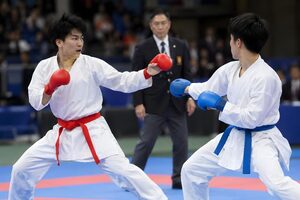 試合場で組手を行う赤帯と青帯の選手