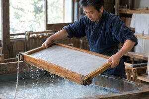 簀桁を水槽から引き上げて和紙を漉く50代の職人