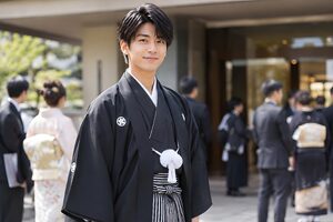 紋付袴で会場の前に立つ20歳の男性