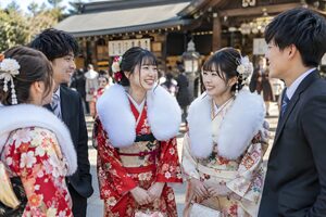 式典の後に神社の前で再会を喜ぶ新成人の男女