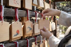 絵馬掛けに絵馬を掛ける手