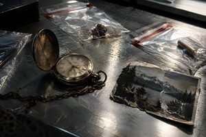 金属の台に並ぶ証拠袋と懐中時計