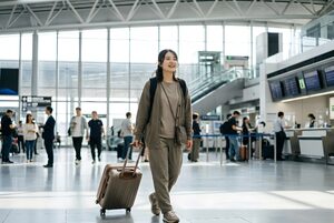 スーツケースを引いて空港を歩く留学生