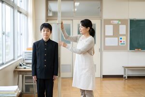 身長を測る養護教諭と男子生徒