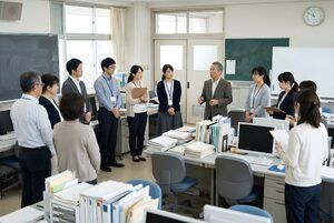 職員室で朝礼をする先生たち