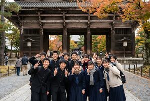 お寺の門の前で集合写真を撮る修学旅行の生徒たち