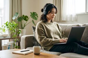 ソファでオンライン講義を受ける大学生