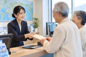 旅行書類を手渡すスタッフ