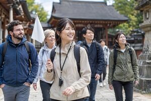 旗を持って観光客を案内するガイド