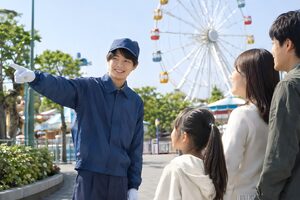 手で案内する遊園地のスタッフ