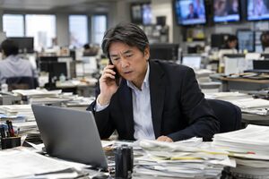 編集部で電話する新聞記者