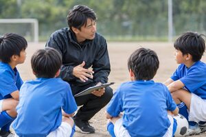 少年サッカーの子どもに話すコーチ