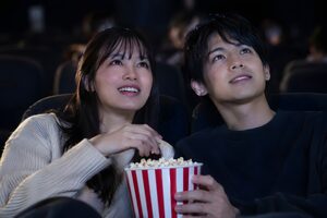 映画館でポップコーンを分け合うカップル