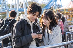 アトラクションの列で話すカップル