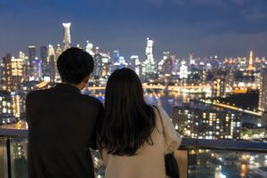 街の夜景を眺めるカップルの後ろ姿