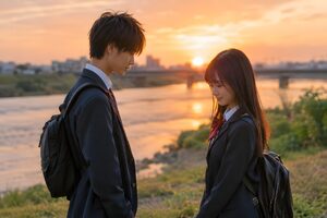 夕暮れの河原で向き合う男女の高校生