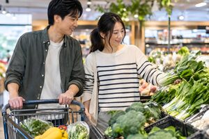スーパーで一緒に買い物をするカップル