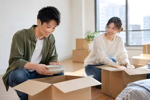 新居で段ボールを開けるカップル