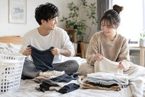 一緒に洗濯物をたたむカップル