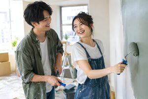 新居の壁を一緒に塗る新婚夫婦