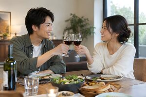 新居のダイニングで乾杯する新婚夫婦