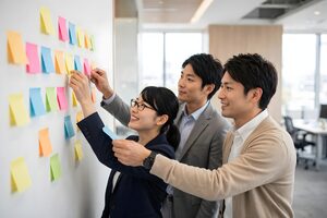 壁の付箋にアイデアを貼り出すチーム
