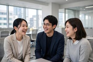 オフィスで笑い合う3人の同僚